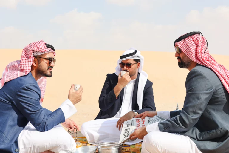 Un groupe d’hommes assis au sommet d’une plage de sable
