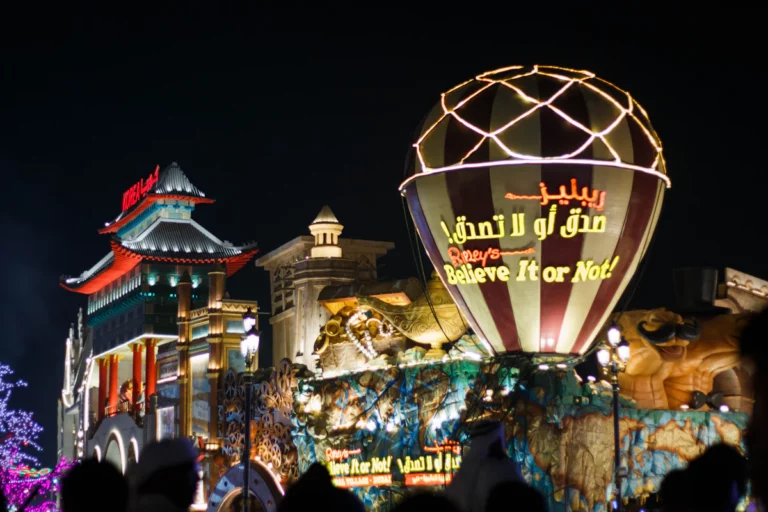 un grand panneau illuminé devant un bâtiment avec une grande foule
