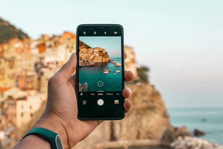 Personne tenant un téléphone près d’une falaise pendant la journée