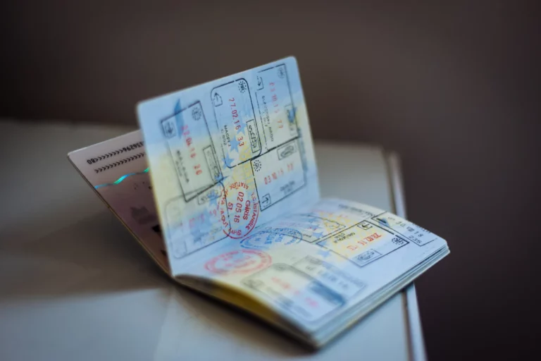 Un passeport ouvert avec de nombreux tampons d’encre sur les pages d’une table